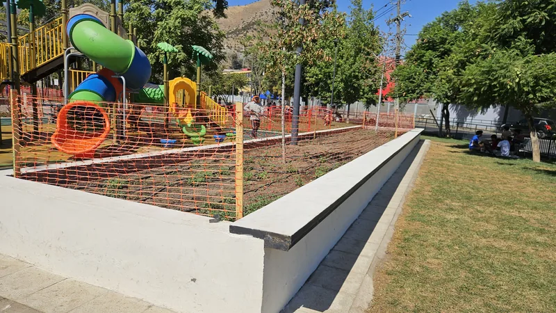 Juego infantil junto a una franja de césped en la Plaza Cívica de Huechuraba